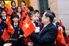 El presidente de la Asamblea Nacional, Tran Thanh Man, con niños y miembros de la comunidad vietnamita en China. Foto: