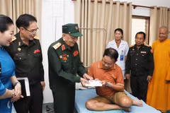 El mayor general Vo Van Chot, ex comandante adjunto de la Región Militar 4 entrega regalo al soldado herido laosiano (Fuente: VNA)
