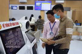 En la ciudad de Dong Nai, funcionarios del Centro de Servicios Administrativos Públicos orientan a los ciudadanos sobre cómo buscar información acerca de los trámites administrativos a través del sistema de IA. Foto: VNA.