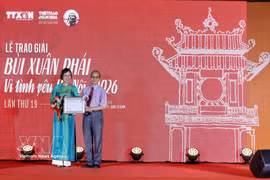Vu Viet Trang, directora general de la VNA entrega el premio al escritor Bang Viet. Foto: VNA