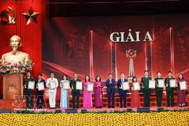 Tran Cam Tu, miembro del Buró Político y permanente del Secretariado del Comité Central del Partido Comunista de Vietnam, y Bui Thi Minh Hoai, presidenta del Comité Central del Frente de la Patria de Vietnam, entregaron el Premio A a los autores y grupos de autores. (Foto: VNA)