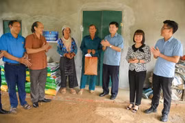 El presidente del Comité del Frente de la Patria de Vietnam de la provincia de Dien Bien, Mua A Vang, entrega regalos a una familia que recibe apoyo para construir una casa en la comuna de Pu Nhi. Foto: mattran.org.vn