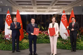El secretario general To Lam (primero a la izquerda), y el primer ministro Lawrence Wong (primero a la derecha), presencian el intercambio de un memorando de entendimiento sobre transformación digital entre el Ministerio de Seguridad Pública de Vietnam y el Ministerio de Desarrollo Digital e Información de Singapur. (Foto: VNA)