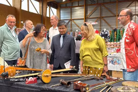 Los delegados aprenden sobre instrumentos musicales tradicionales vietnamitas, que se exhiben en el 4º Festival de Japón de Maintenon-Pierres. Foto: VNA
