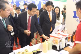 Los delegados visitan los stands de las empresas vietnamitas de procesamiento de alimentos en el evento. Foto: VNA
