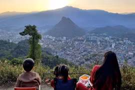 Turistas ven la puesta de sol sobre la ciudad de Hà Giang desde la montaña Mỏ Neo.— Foto: VNA