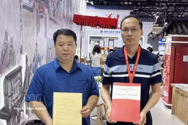 Phung Huy Cuong (izquierda), director y editor jefe de la Editorial de Cultura Étnica intercambia un memorándum de entendimiento con la editorial Fujian Science and Technology Publishing de China. Foto: VNA