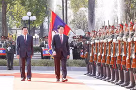 El presidente de Vietnam, Luong Cuong (derecha), y el secretario general del Comité Central del Partido Popular Revolucionario Lao (PLRP) y presidente de Laos, Thongloun Sisoulith, pasan revista a la guardia de honor en la ceremonia de bienvenida (Foto: VNA)