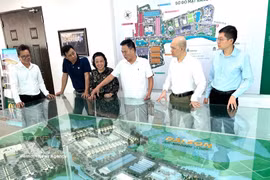 El empresario Nguyen Hoai Bac (tercero desde la derecha) muestra a los visitantes una maqueta del área urbana de Dai Son, de la cual es inversor. Foto: VNA