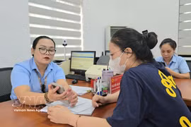Funcionarios del barrio de Mao Khe orientan a los ciudadanos sobre cómo presentar sus documentos de autenticación en el Portal Nacional de Servicios Públicos. Foto: VNA.