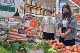 Los consumidores eligen manzanas estadounidenses en un supermercado de la ciudad de Ho Chi Minh. (Foto: nld.com.vn)