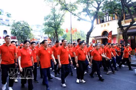 Los delegados participan en un recorrido a pie alrededor del lago Hoan Kiem. Foto: VNA