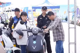 Consumidores prueban una motocicleta eléctrica de VinFast. (Foto: VNA)