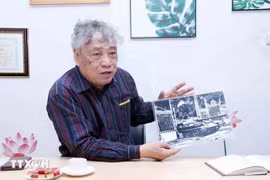 El periodista Tran Mai Huong con la foto titulada "El tanque del Ejército de Liberación entra al Palacio de Independencia al mediodía del 30 de abril de 1975"(Fuente: VNA)