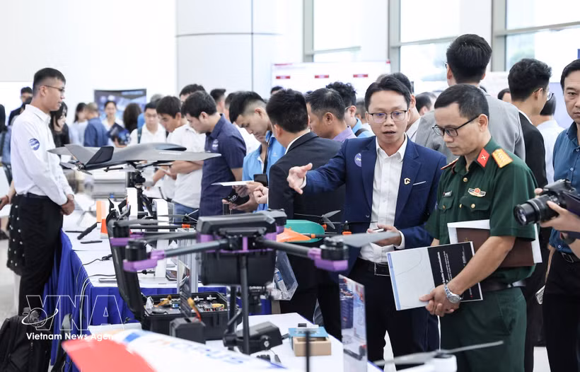 Los delegados visitan los stands de la exposición durante la ceremonia de anuncio de las 3 Redes Estratégicas de Innovación de la Industria Tecnológica el 25 de agosto de 2025. (Foto: VNA)