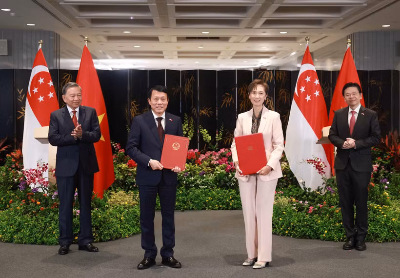 El secretario general To Lam (primero a la izquerda), y el primer ministro Lawrence Wong (primero a la derecha), presencian el intercambio de un memorando de entendimiento sobre transformación digital entre el Ministerio de Seguridad Pública de Vietnam y el Ministerio de Desarrollo Digital e Información de Singapur. (Foto: VNA)