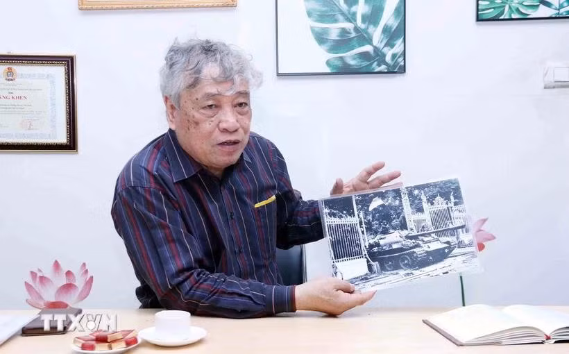 El periodista Tran Mai Huong con la foto titulada "El tanque del Ejército de Liberación entra al Palacio de Independencia al mediodía del 30 de abril de 1975"(Fuente: VNA)