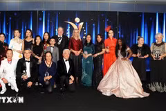 La embajadora adjunta de Vietnam en el Reino Unido, To Minh Thu (con un Ao Dai verde), se toma una foto con los ganadores. (Foto: VNA)