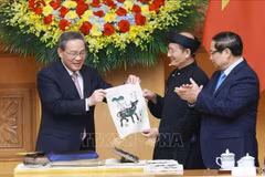 El primer ministro vietnamita, Pham Minh Chinh (derecha), y su par chino, Li Qiang, experimentaron de primera mano la creación de una pintura popular de la etnia Dong Ho. (Foto: VNA)