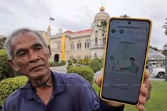 Un jardinero tailandés muestra un mensaje en su teléfono en respuesta a su registro en el sistema de billetera digital. (Foto: bangkokpost.com)