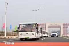 Los vehículos eléctricos que transportan a los turistas pasan por la línea divisoria del puente Bac Luan II (Foto: VNA)