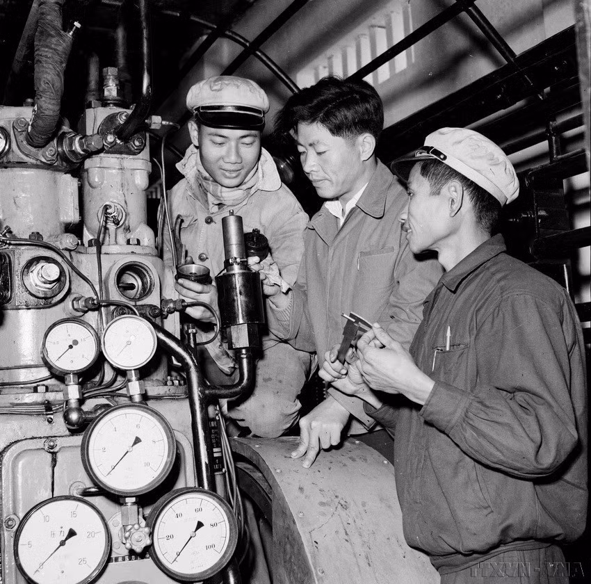 Expertos chinos (en el centro) instruyeron a trabajadores vietnamitas para desmontar y reparar válvulas automáticas de liberación de vapor en la planta de prensado K65 (septiembre de 1960). Foto: VNA