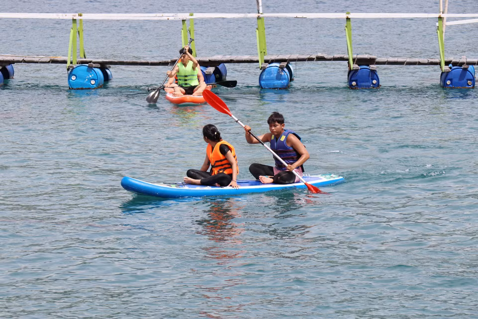 Los turistas experimentan la experiencia de remar en un bote en la bahía de Vinh Hy, en la comuna de Vinh Hai, provincia de Khanh Hoa. (Foto: VNA)