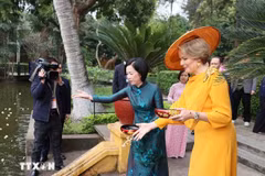 Nguyen Thi Minh Nguyet, esposa del presidente Luong Cuong, y la reina Matilde de Bélgica, alimentan a los peces en el estanque de Tío Ho, en el sitio de reliquias del Presidente Ho Chi Minh. (Foto: VNA)