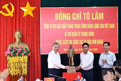 El secretario general To Lam (izquierda) entrega una estatua del Presidente Ho Chi Minh a la comuna de Dat Mui, provincia de Ca Mau. (Foto: VNA)