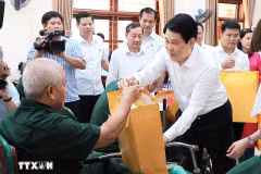 El presidente Luong Cuong entrega obsequios a Nguyen Xuan Mai, inválido de guerra, quien recibe tratamiento en el Centro de Rehabilitación de Veteranos de Guerra de Duy Tien. (Foto: VNA)