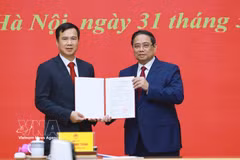 El primer ministro Pham Minh Chinh (derecha) entrega la decisión de nombramiento de Bui The Duy como director de la Universidad Nacional de Hanoi. (Foto: VNA)