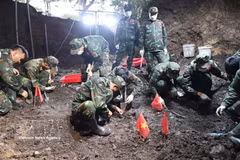 Oficiales y soldados del Equipo K74 realizan la búsqueda y recuperación de los restos de los soldados caídos en la fosa común recientemente descubierta. (Foto: VNA)