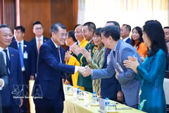 El primer ministro vietnamita, Le Minh Hung, y los funcionarios de la Embajada y representantes de la comunidad de connnacionales en Laos. Foto: VNA