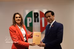 El subdirector de la Academia Nacional de Política Ho Chi Minh, Hoang Phuc Lam, entrega el libro "La aspiración de un Vietnam fuerte y próspero en la nueva era" a Sofia Carvajal, secretaria de Asuntos Internacionales del Partido Revolucionario Institucional (PRI). Foto: VNA
