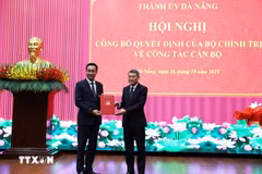 Le Minh Hung, (derecha) miembro del Buró Político, secretario del Comité Central del PCV y jefe de su Comisión de Organización, presenta la decisión del nombramiento a Le Ngoc Quang. (Foto: VNA)