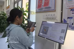 Una ciudadana escanea el código QR para obtener el turno en el Centro de Servicios Administrativos Públicos del barrio de Hoa Xuan, Da Nang. (Foto. VNA)
