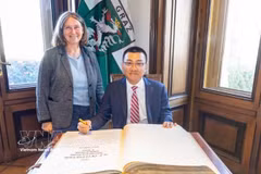 Elke Kahr, dirigente del Partido Comunista y alcaldesa de Graz, y el embajador Vu Le Thai Hoang firman el libro de oro de la ciudad de Graz. (Foto: VNA)