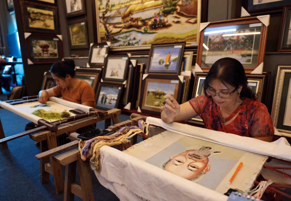 La artista Le Thi Xuan se empeña en elaborar el cuadro de bordado sobre el lago Hoan Kiem. (Foto: VNA)