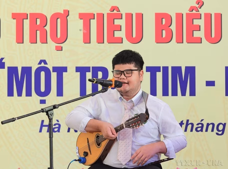 Bui Ngoc Thinh, una persona con discapacidad visual de la provincia de Khanh Hoa que domina 14 instrumentos musicales y ha ganado numerosos premios, habló en una conferencia en homenaje a los discapacitados, huérfanos y benefactores destacados del país, en el marco de la cual también se desarrolló el programa "Un corazón-Un Mundo". (Foto: VNA)