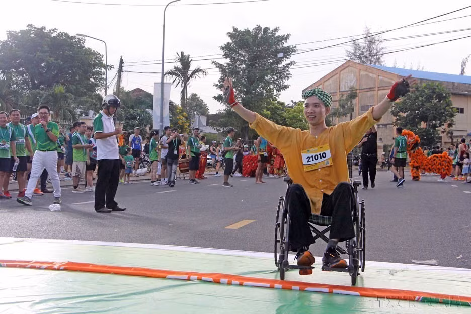 Un atleta discapacitado completa la carrera de 500 metros en un torneo benéfico. (Foto: VNA)