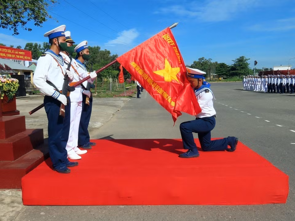 Los soldados realizan la ceremonia de honrar la bandera durante la Ceremonia de Juramento antes de partir hacia las unidades de la Región Naval 2 para cumplir sus misiones. (Foto: VNA)