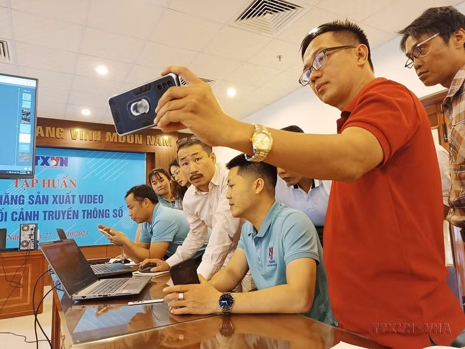 Los periodistas de la Agencia Vietnamita de Noticias discuten sobre las formas de crear vídeos con teléfonos móviles en el curso de habilidades de producción de vídeo en el contexto de los medios digitales, celebrado en Da Nang. (Fuente: VNA)