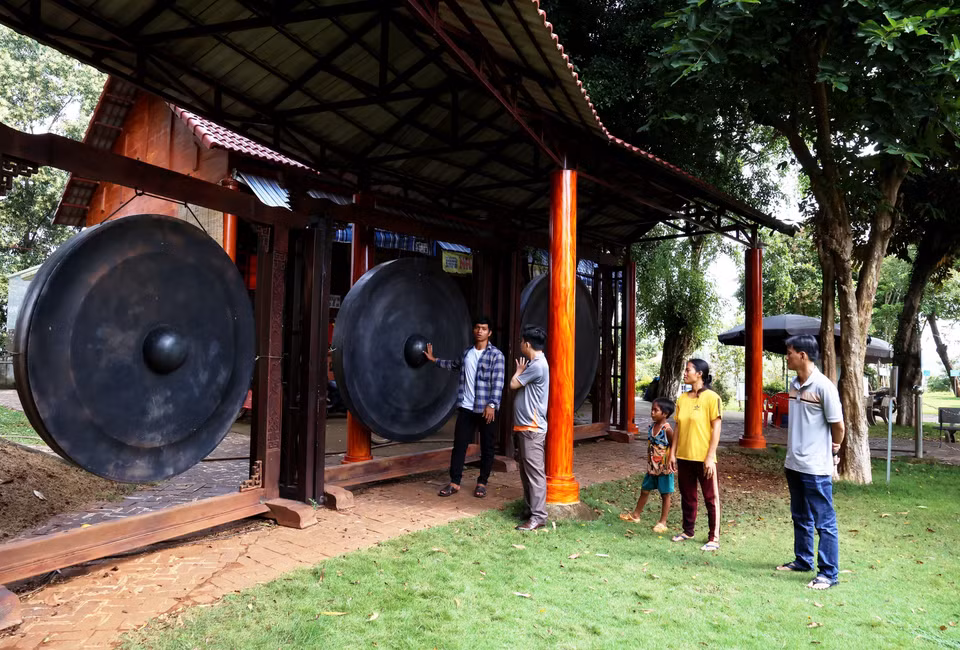 Los turistas aprenden sobre el conjunto de gongs más grande de Vietnam exhibido en el Área. (Foto: VNA)