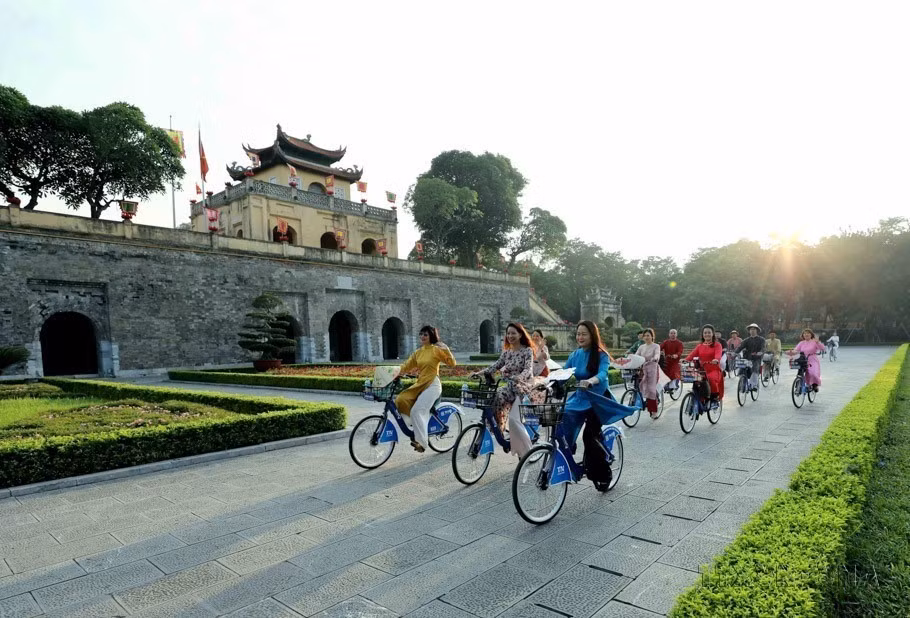 Las mujeres capitalinas vestidas de Ao Dai (túnica tradicional vietnamita) recorren en bicicleta por los sitios patrimoniales de Hanoi. (Foto: VNA)
