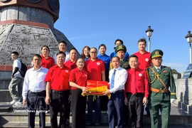 Delegados y turistas en la ceremonia de izamiento de la bandera (Foto: VNA) 
