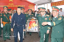 El general Phan Van Giang, miembro del Buró Político, viceprimer ministro y ministro de Defensa Nacional, y Vu Hong Van, secretario del Comité del Partido de la ciudad de Dong Nai, realizan la ceremonia de traslado de los restos de los soldados caídos a la funeraria y ofrenda de incienso. (Foto: VNA)