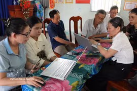 Miembros del equipo comunitario de tecnología digital de la aldea Phuong Quy 2, comuna de Ngok Bay, guían a los residentes en la presentación de trámites administrativos en línea. (Foto: VNA)