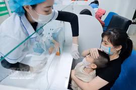 El personal médico toma muestras de gripe para pacientes pediátricos. (Foto: VNA)