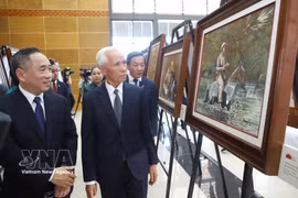 Khamphan Pheuiyavong, jefe del Departamento Central de Propaganda de Laos, y otros delegados visitan la exposición. (Foto: VNA)